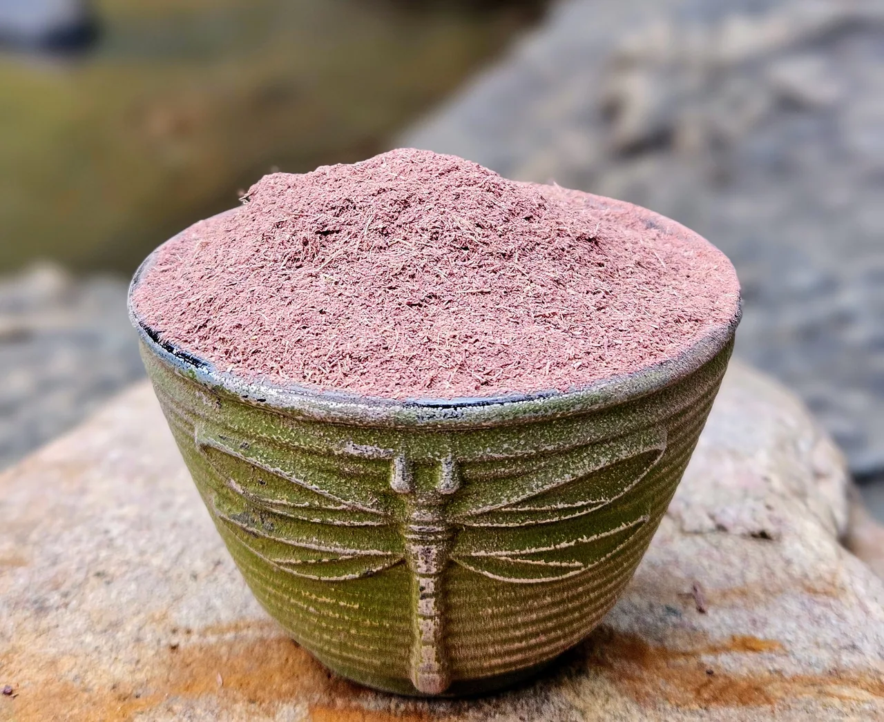 Mimosa hostilis inner root bark powder heaped in a ceramic bowl on a wooden surface