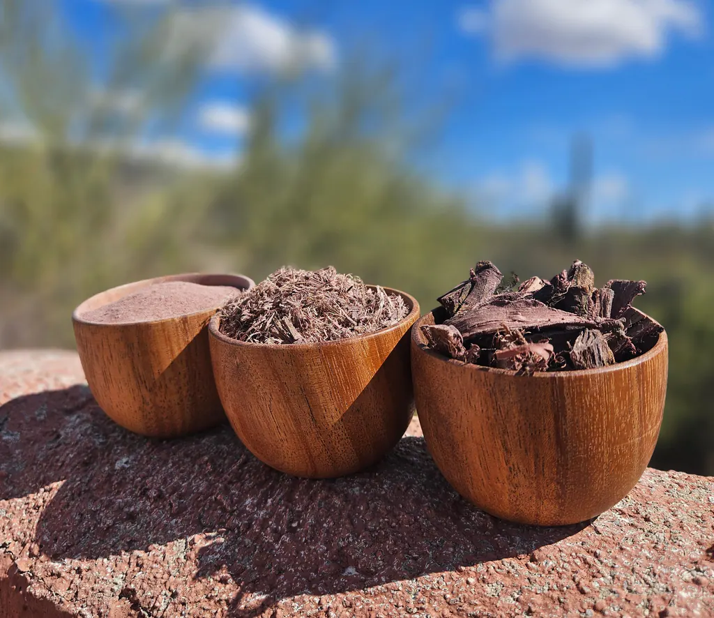 Three bowls of Mimosa hostilis root bark powder, shredded bark, and chips arranged outdoors.